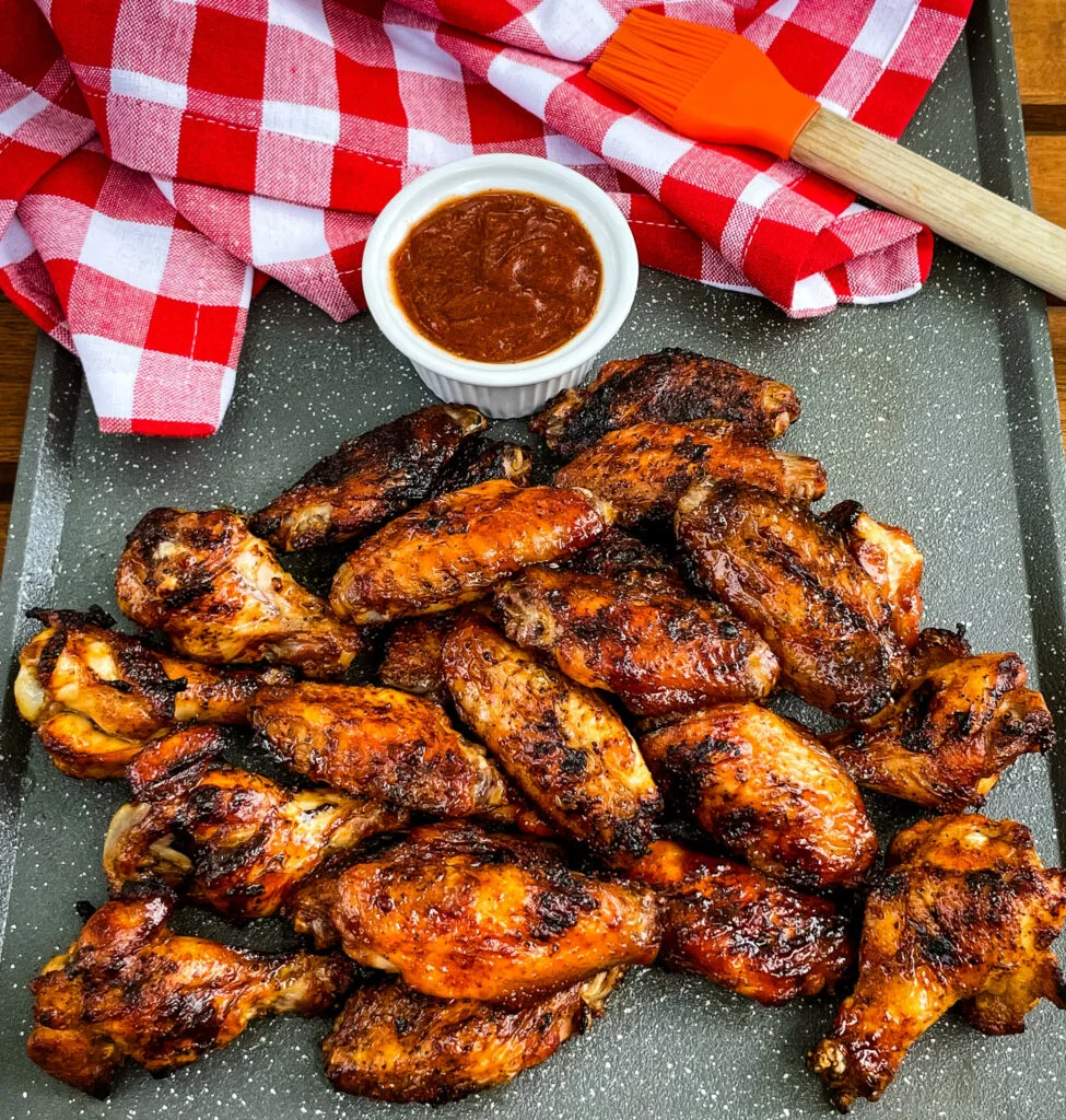 grilled chicken wings on a plate with BBQ sauce