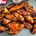 grilled chicken wings on a plate with BBQ sauce