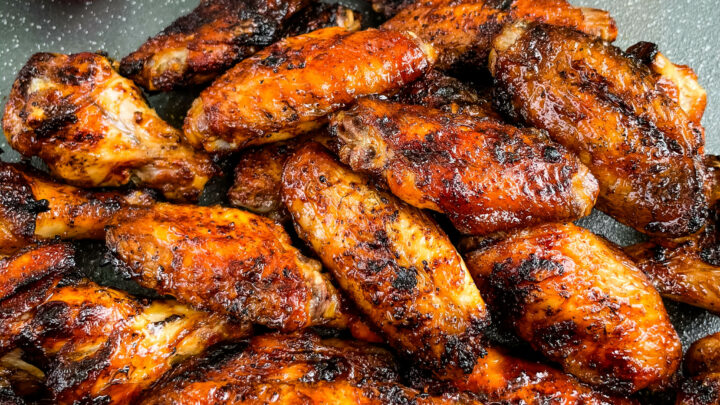 grilled chicken wings on a plate with BBQ sauce