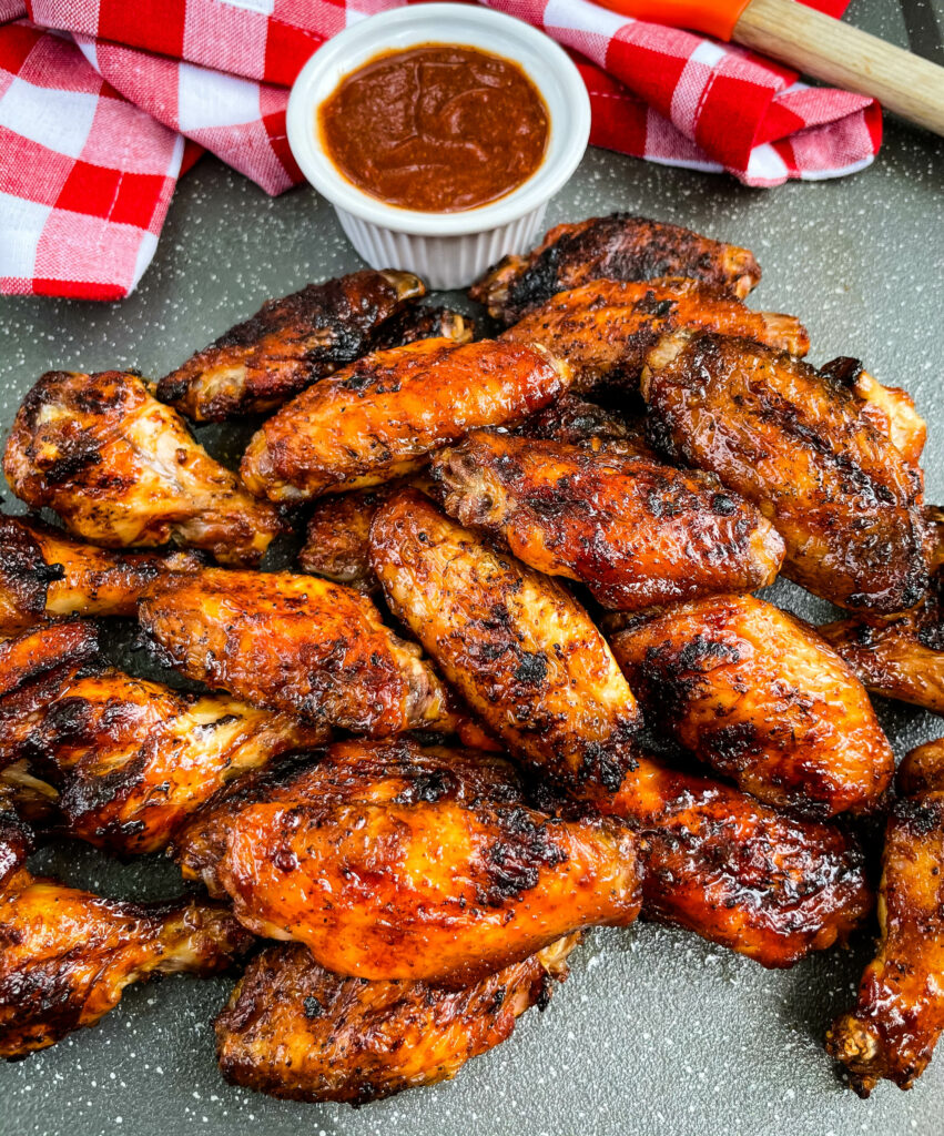 grilled chicken wings on a plate with BBQ sauce