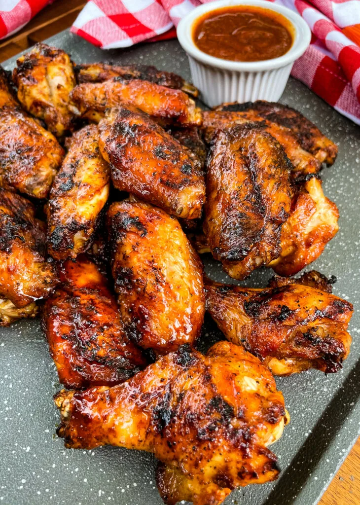 grilled chicken wings on a plate with BBQ sauce