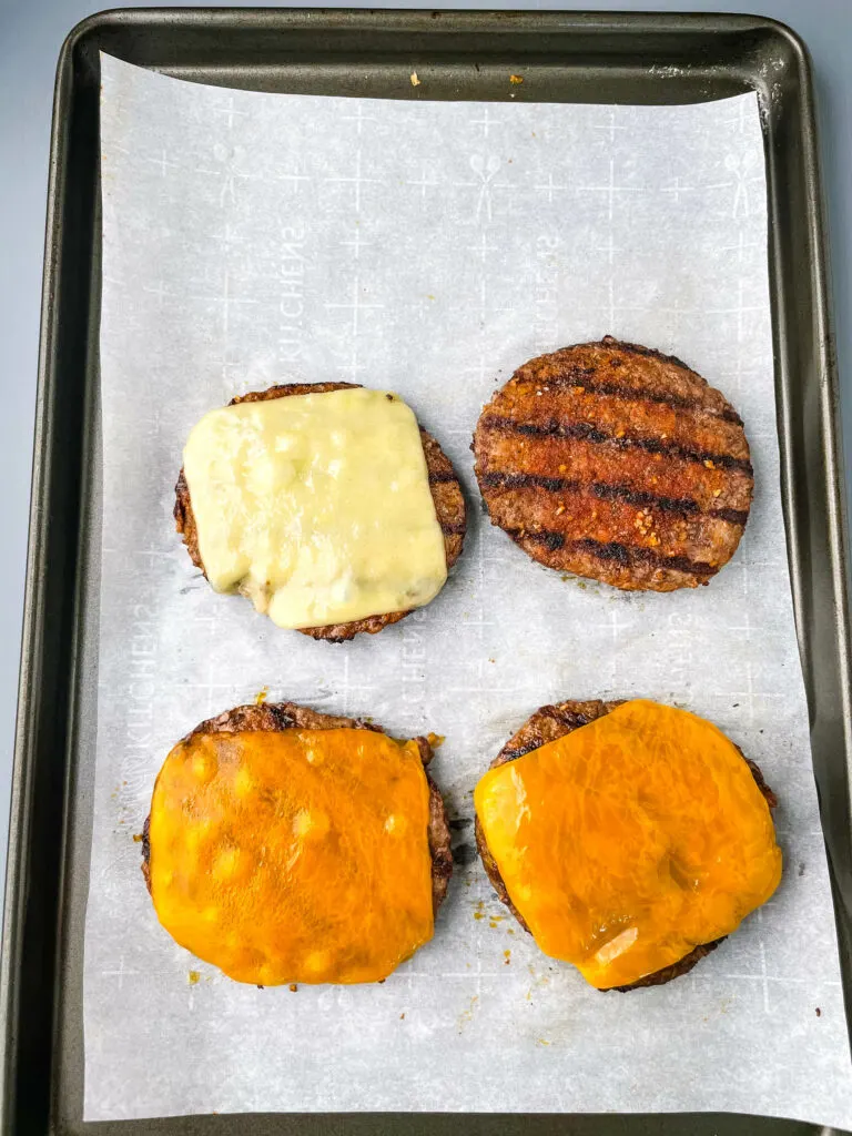 cooked cheeseburgers on a sheet pan