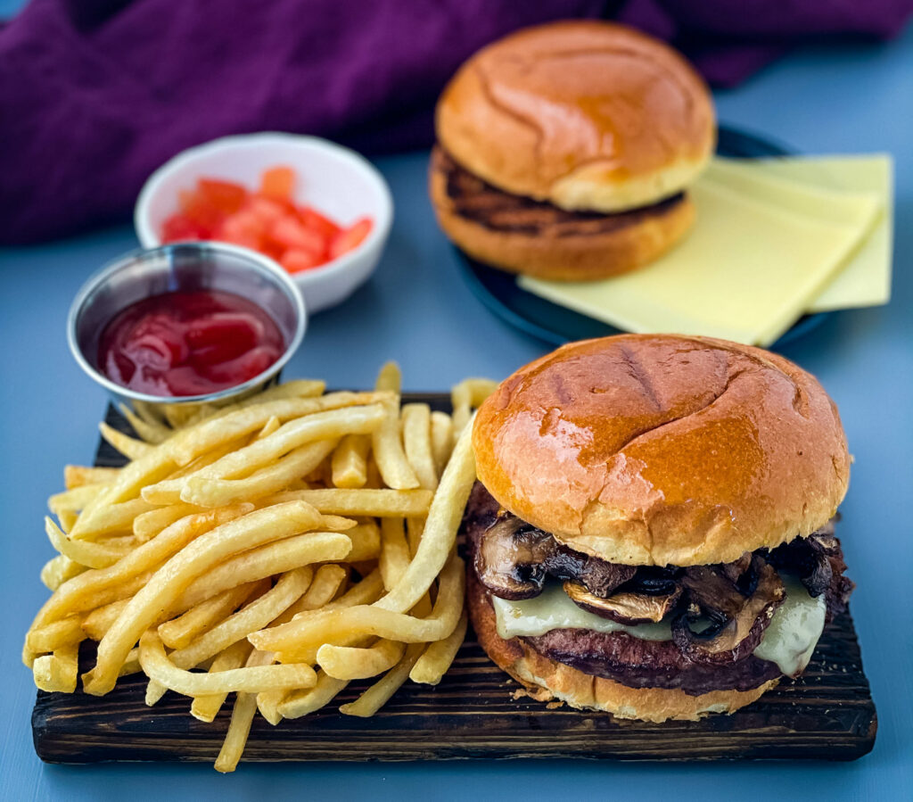 mushroom swiss burger on a plate with French fries