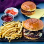 mushroom swiss burger on a plate with French fries