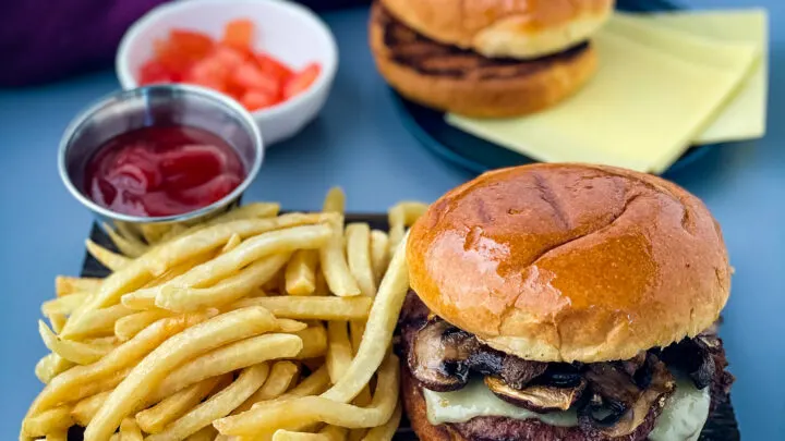 mushroom swiss burger on a plate with French fries
