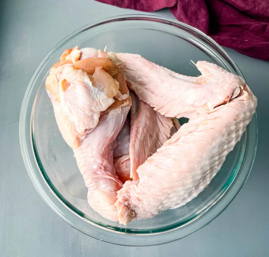 raw split turkey wings in a glass bowl