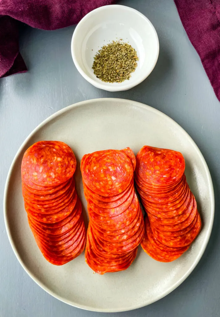 pepperoni on a plate with Italian Seasoning