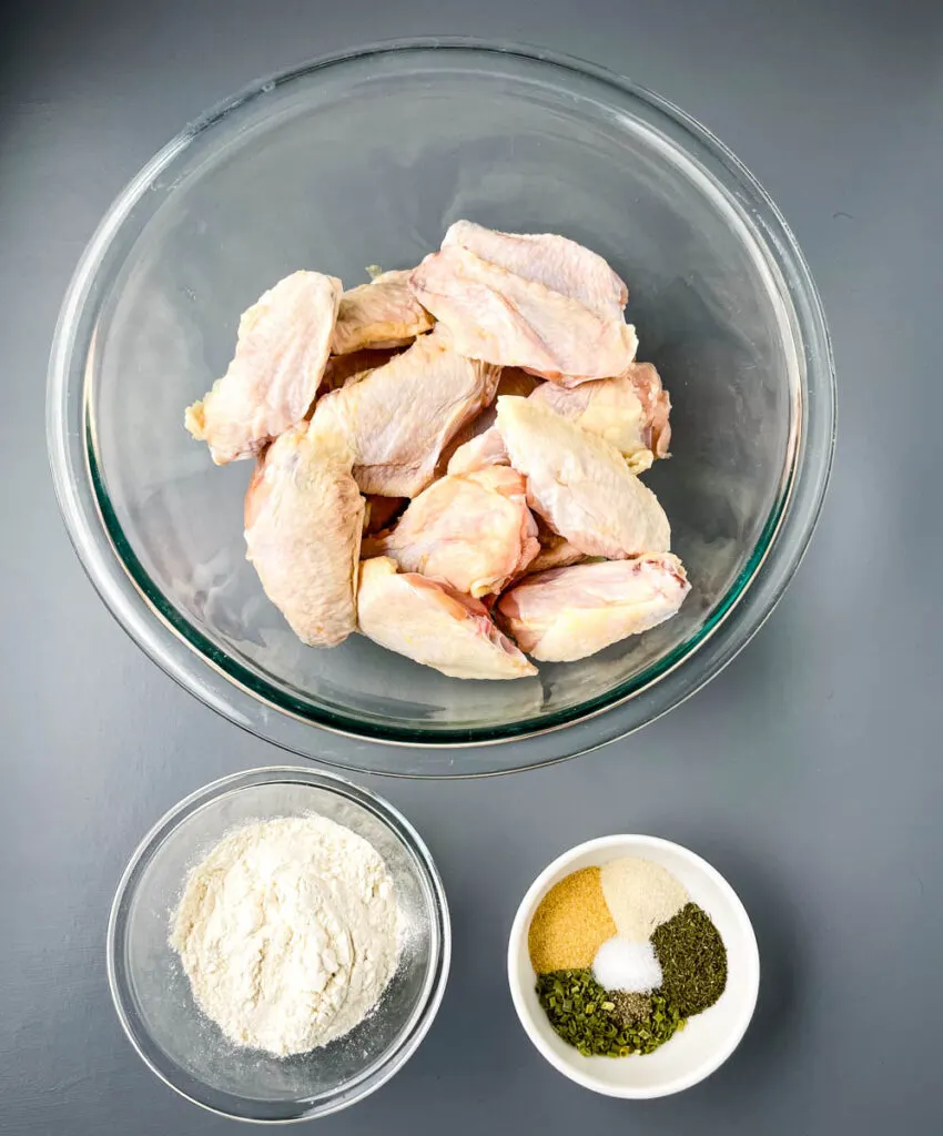 raw chicken wings and homemade ranch seasoning in separate bowls
