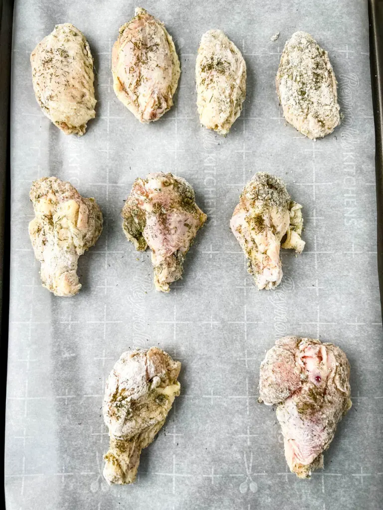 raw ranch chicken wings on a sheet pan with parchment paper