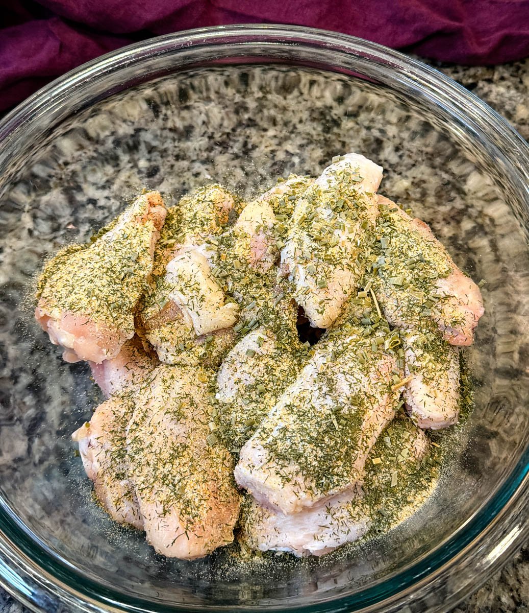 raw chicken wings in a glass bowl with homemade ranch seasoning