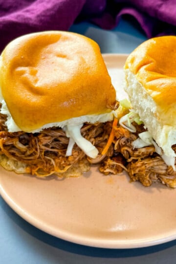 pulled pork sliders with coleslaw on a pink plate