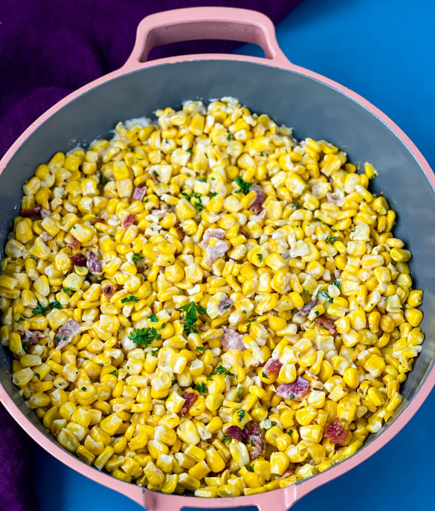 homemade creamed corn in a pink skillet