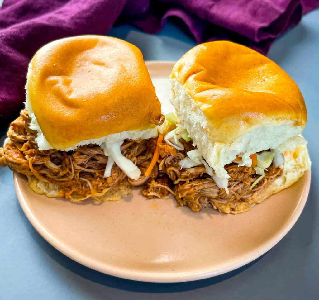 pulled pork sliders with coleslaw on a pink plate