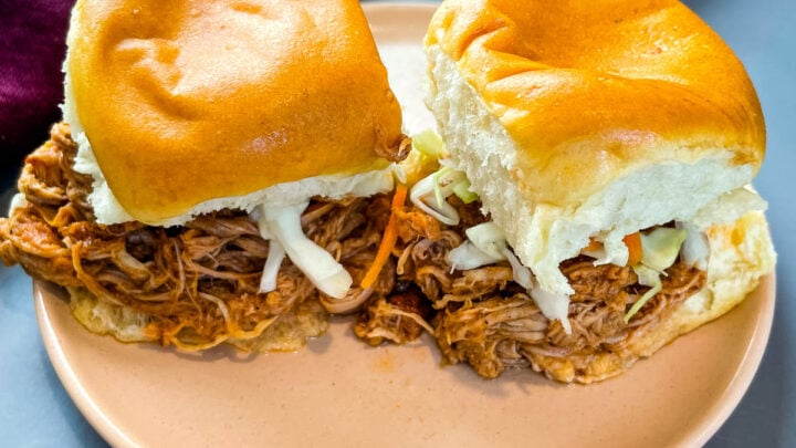 pulled pork sliders with coleslaw on a pink plate