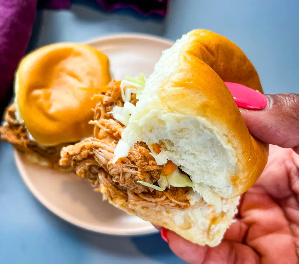 person holding pulled pork slider