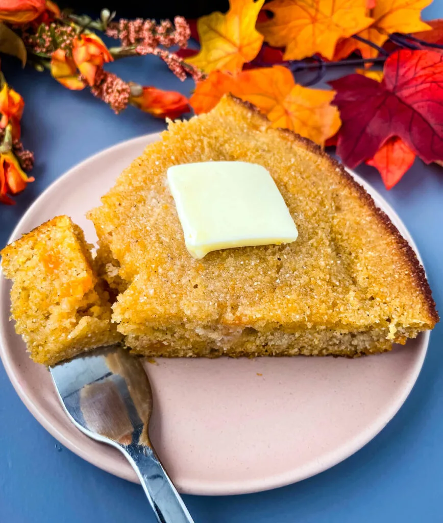 sweet potato cornbread with butter on a plate with a fork and small piece of cornbread