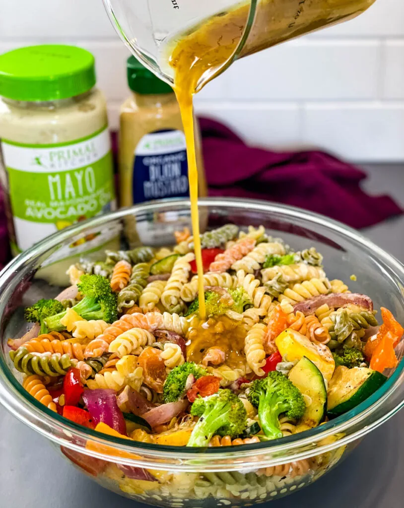 honey dijon mustard drizzled into a bowl of pasta salad