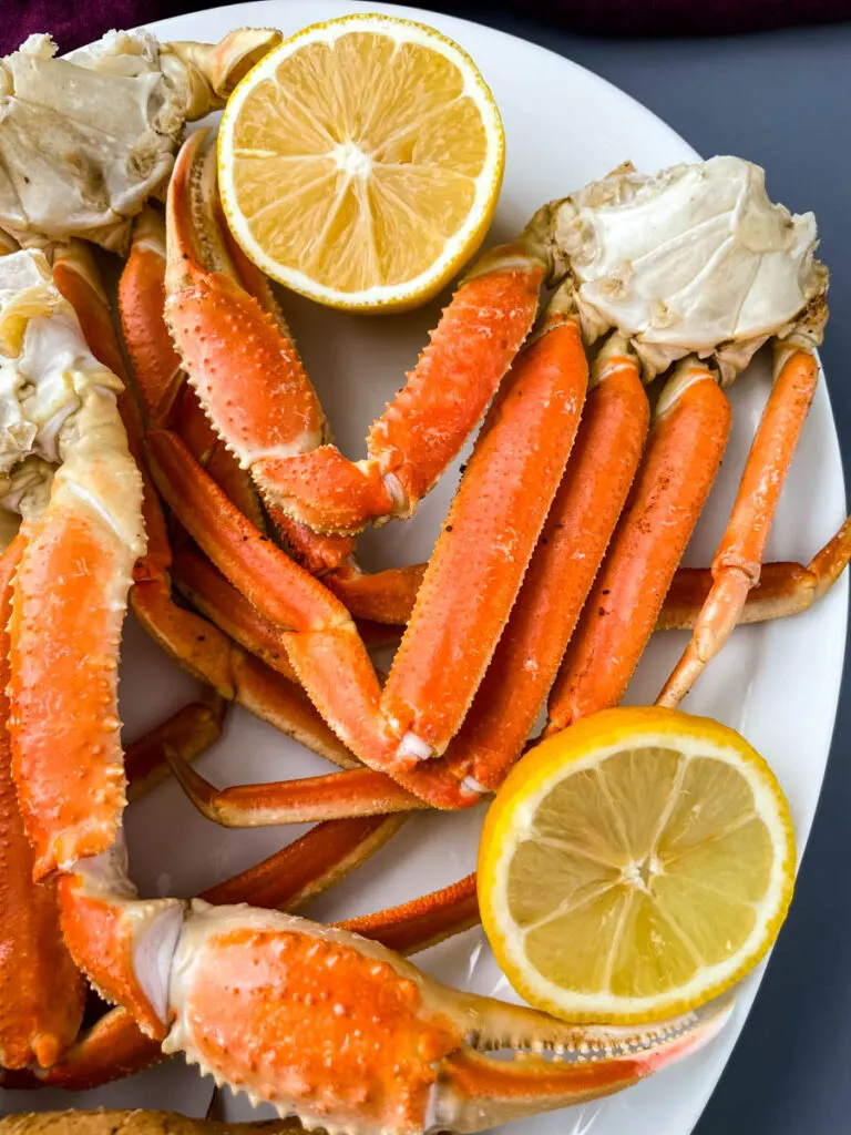 Instant Pot crab legs on a white plate with lemon