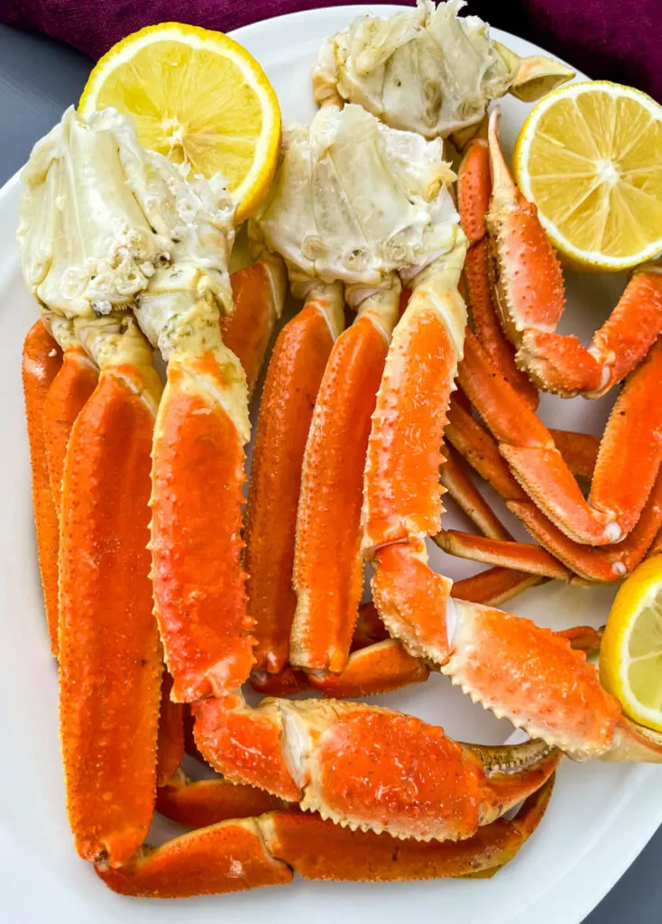 Instant Pot crab legs on a white plate with lemon