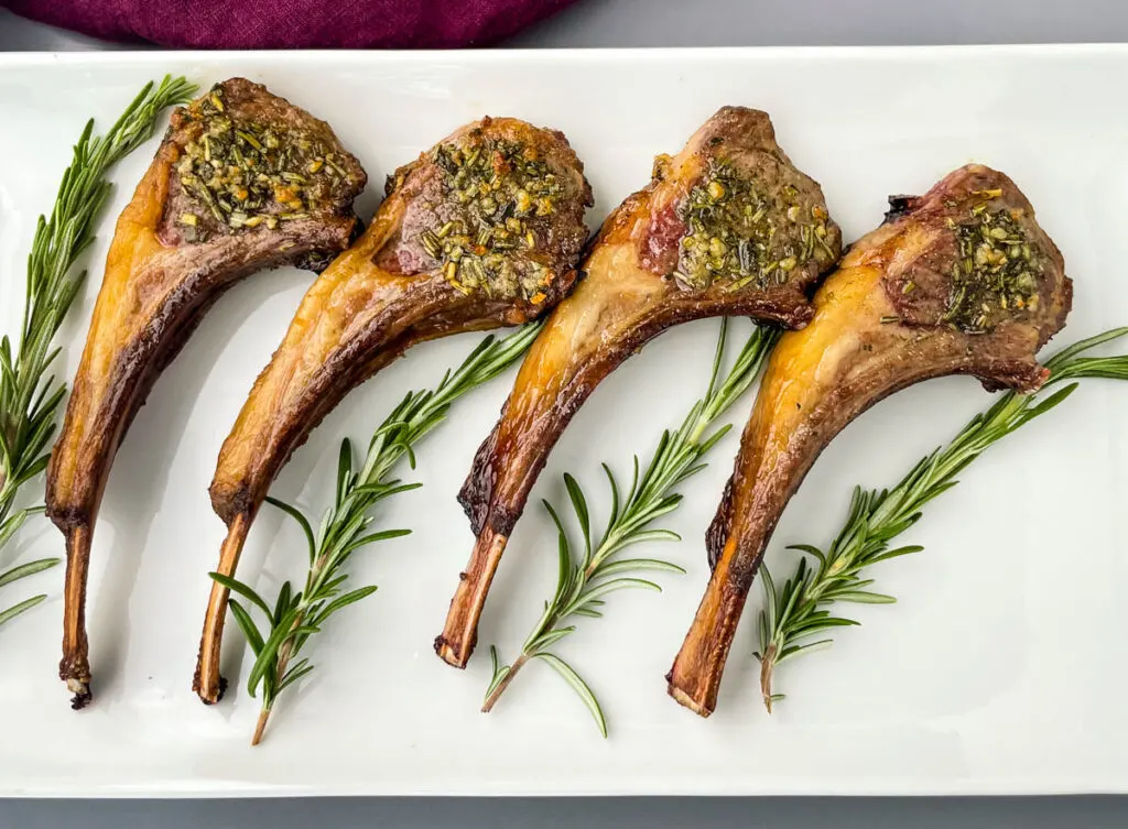 air fryer lamb chops on a white plate with rosemary