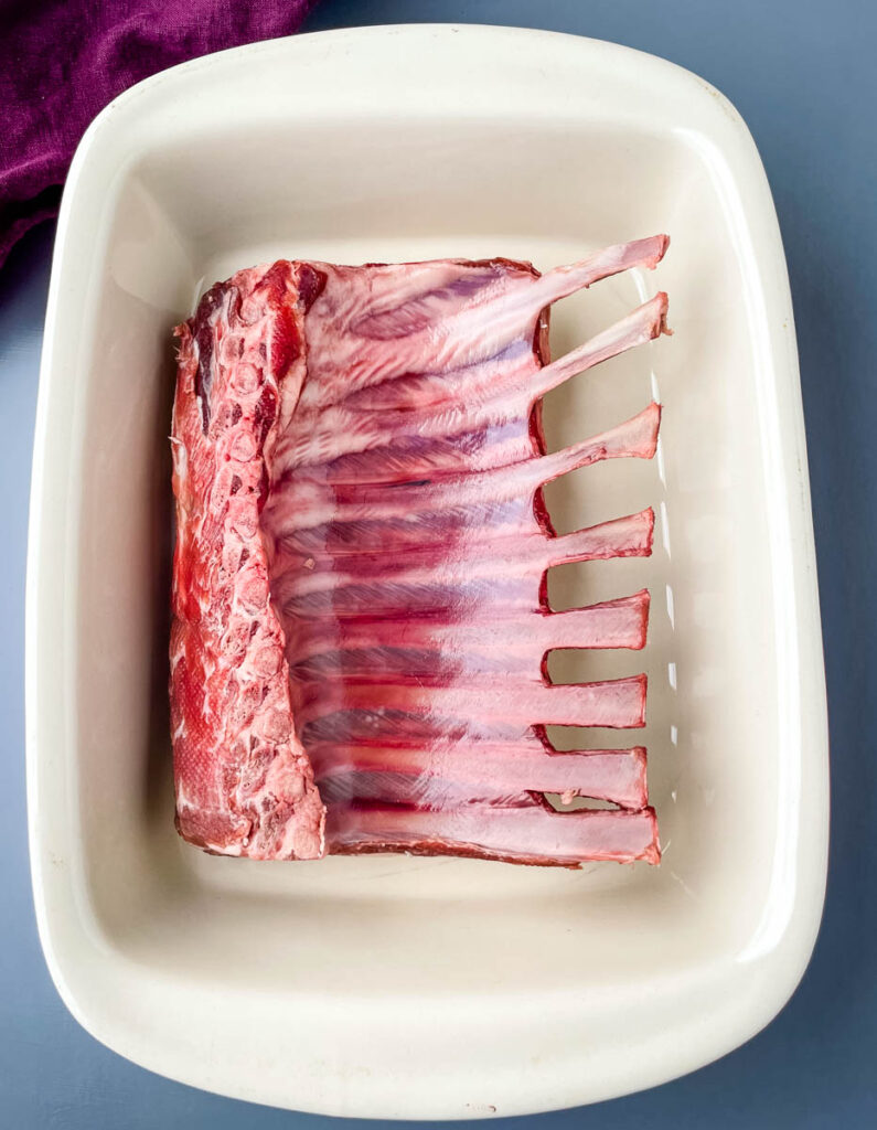 raw rack of lamb in a baking dish