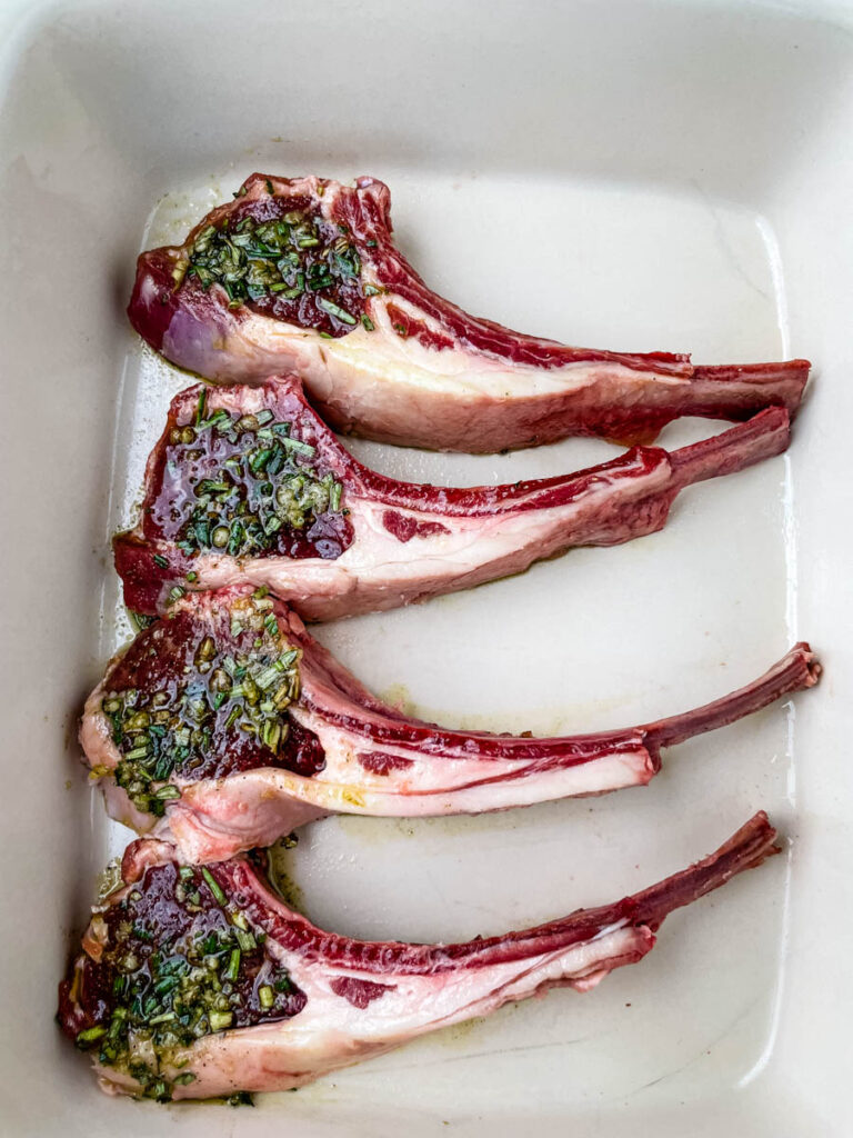 raw seasoned lamb chops in a baking dish