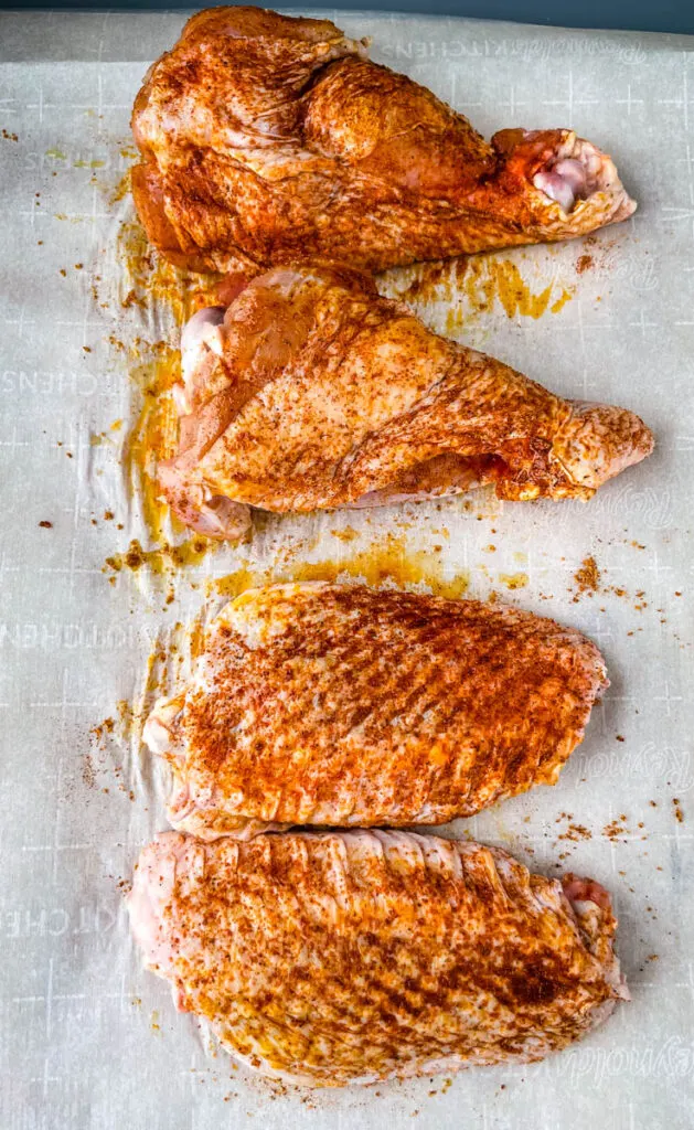 raw seasoned turkey wings on parchment paper