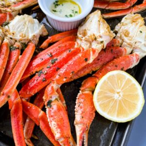 baked crab legs on a pan with lemon garlic butter