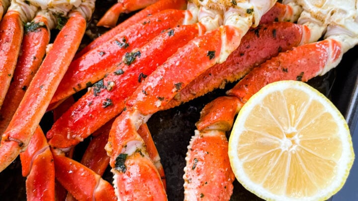 baked crab legs on a pan with lemon garlic butter