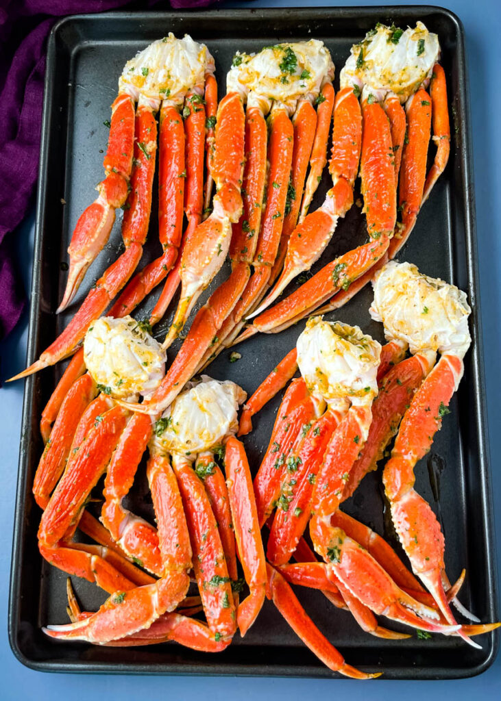 baked crab legs on a pan with lemon garlic butter