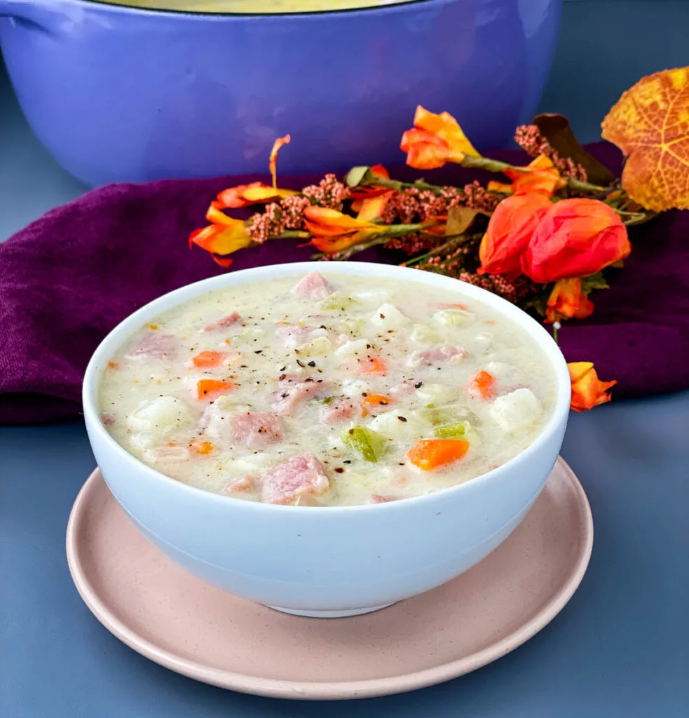 creamy ham, potato, and vegetable soup in a white bowl