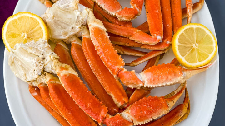Instant Pot crab legs on a white plate with lemon