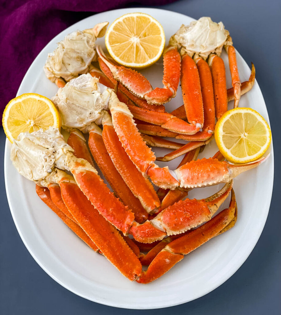 Instant Pot crab legs on a white plate with lemon