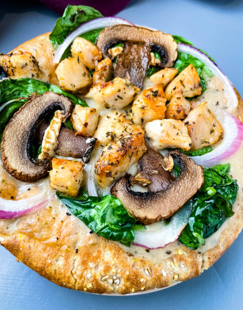 pita bread pizza with spinach, chicken, mushrooms, and onions