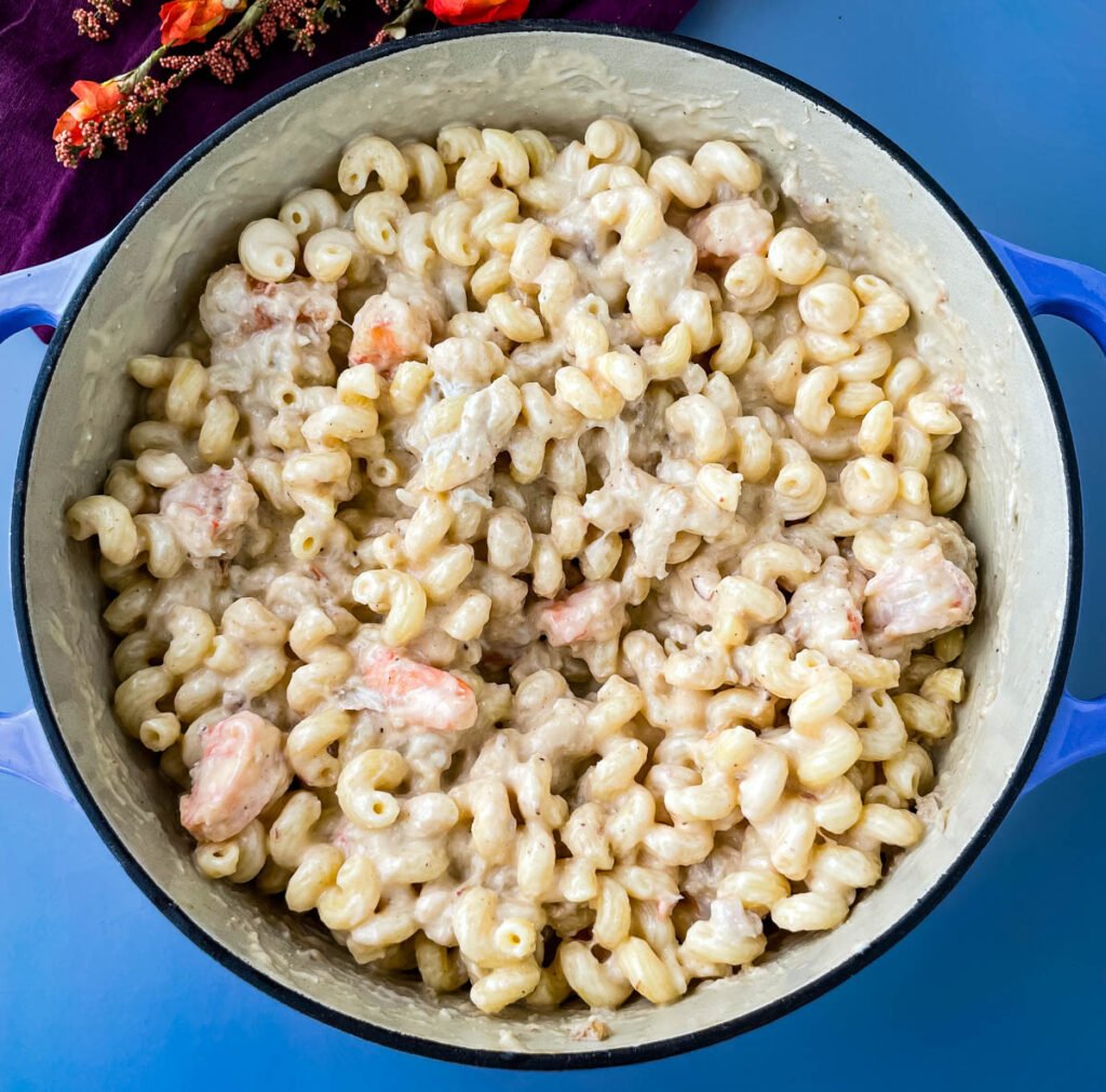 cooked pasta in a Dutch oven with mac and cheese cream sauce, crab, and shrimp
