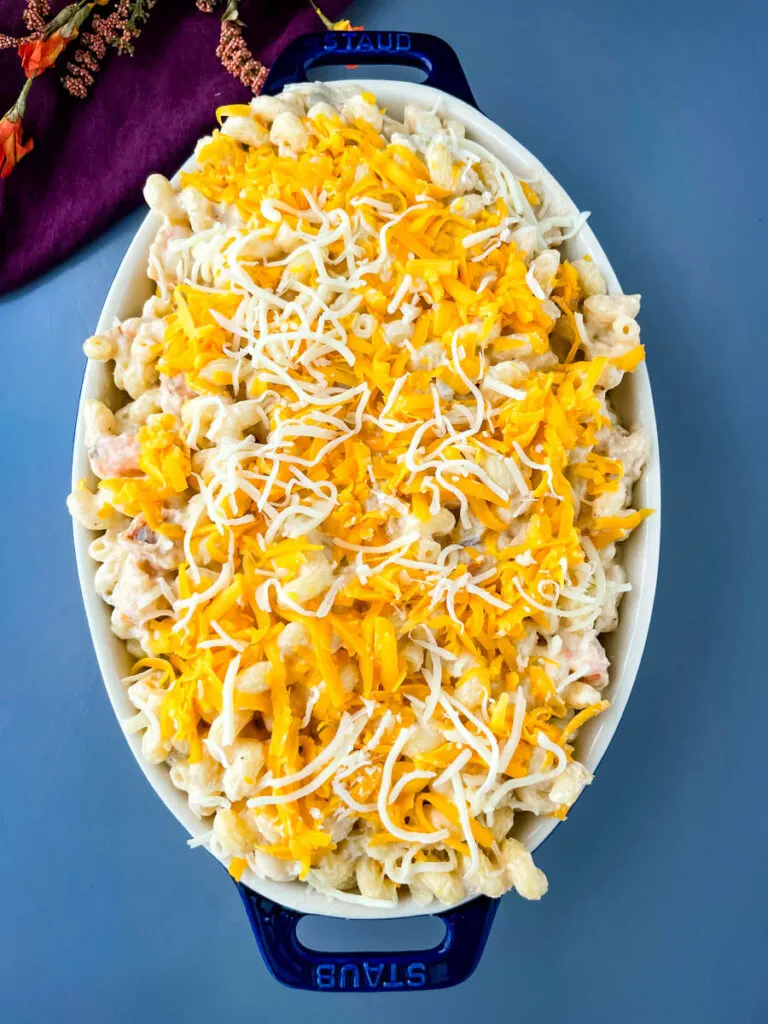 un baked mac and cheese topped with shredded cheese in a baking dish