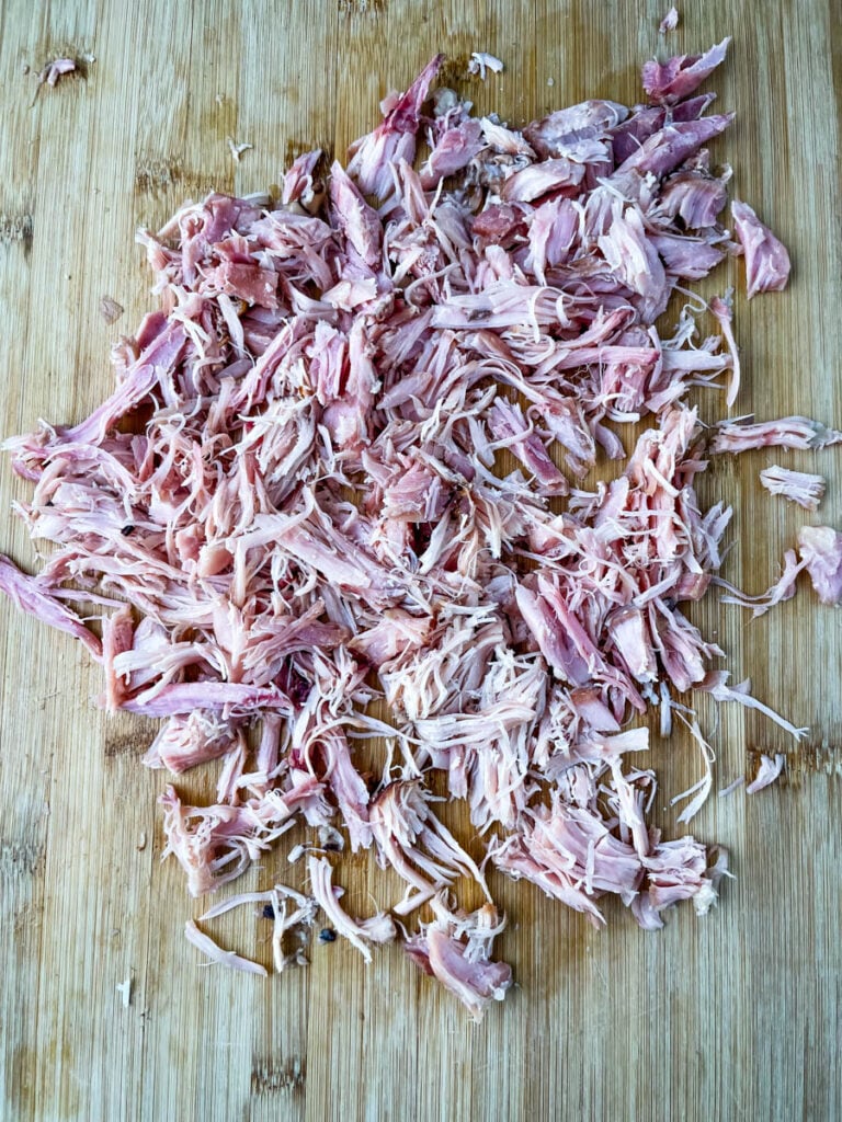 shredded smoked turkey on a bamboo cutting board