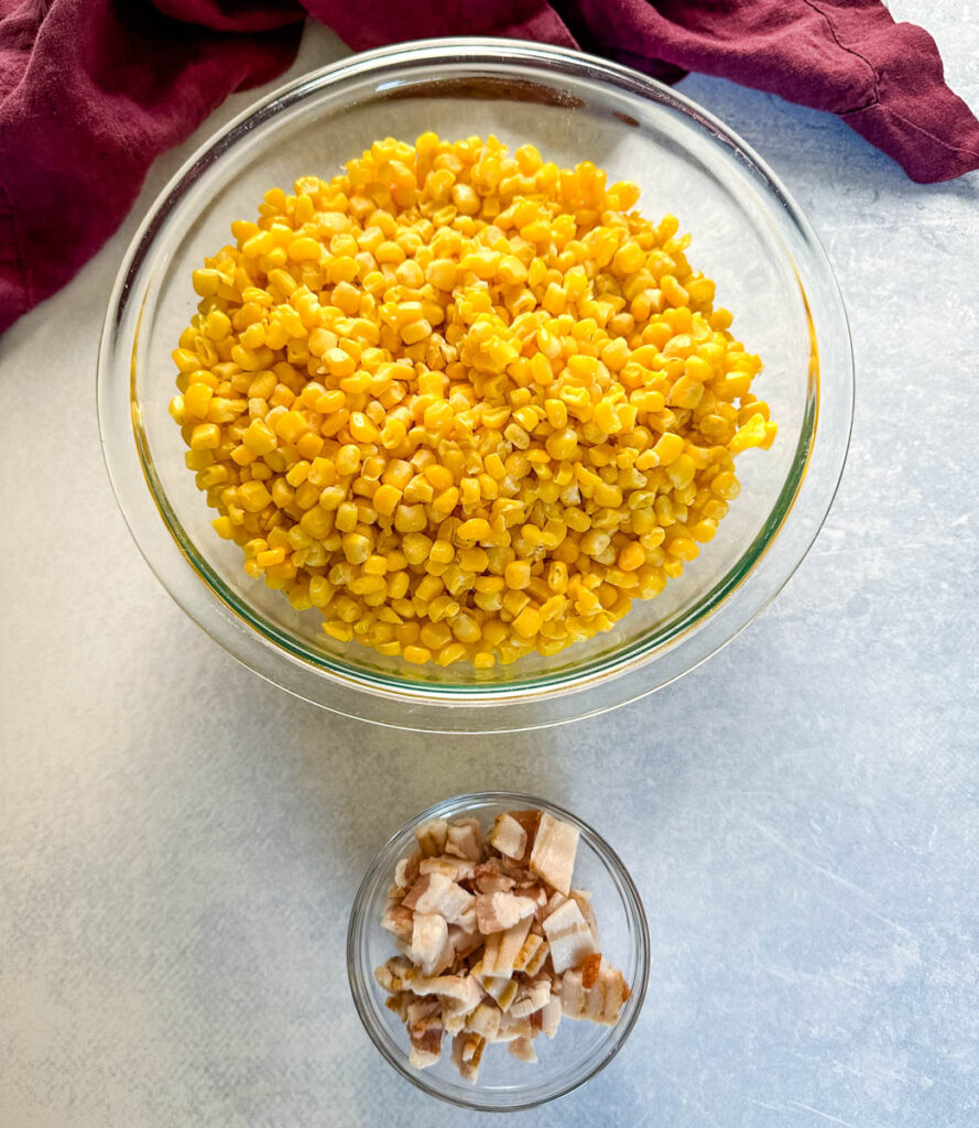 frozen corn in a glass bowl and chopped bacon in a glass bowl
