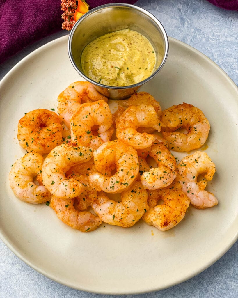 cooked air fryer frozen shrimp on a plate with sauce