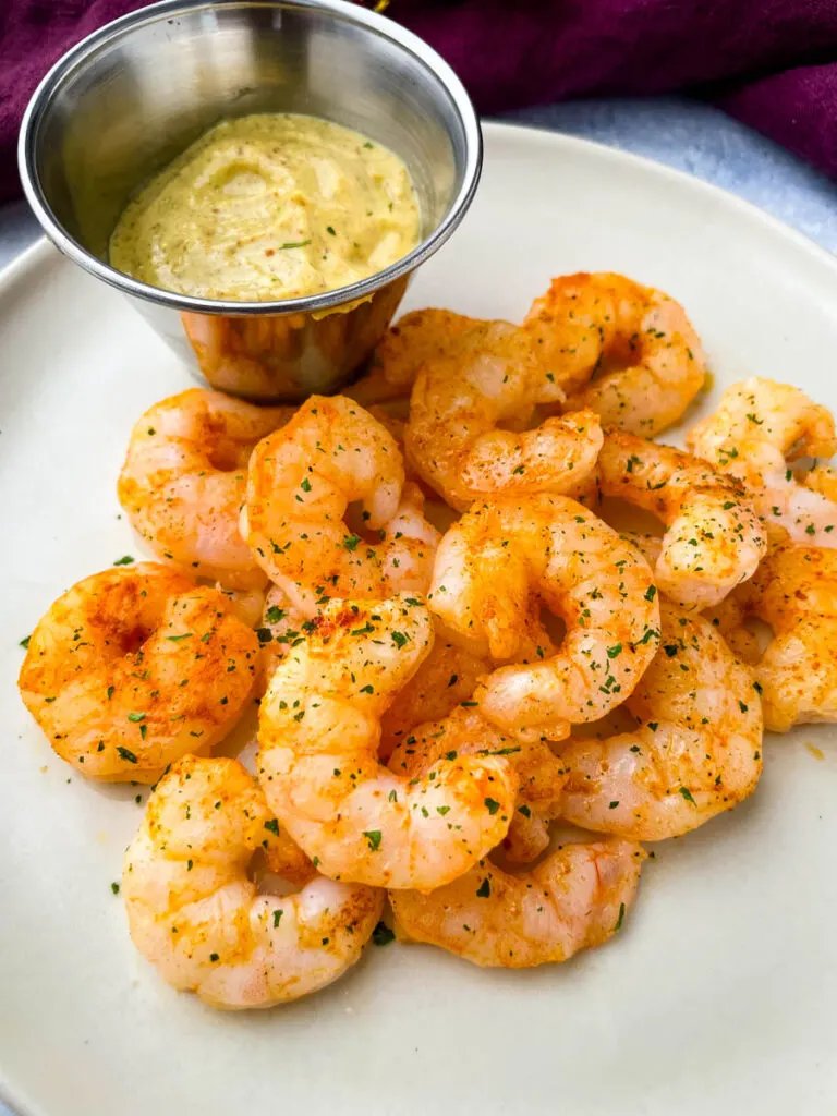 cooked air fryer frozen shrimp on a plate with sauce