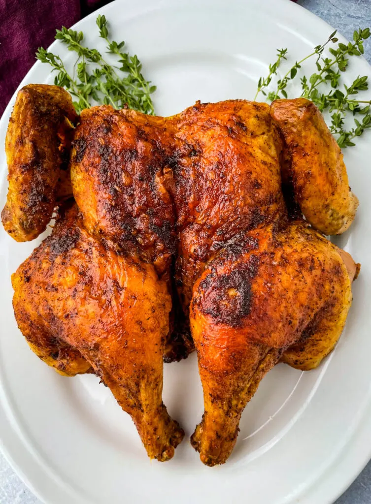 seasoned spatchcock chicken on a white plate