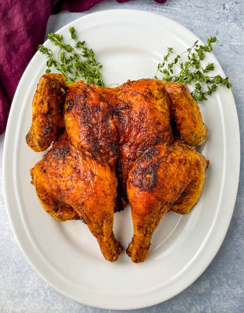 seasoned spatchcock chicken on a white plate