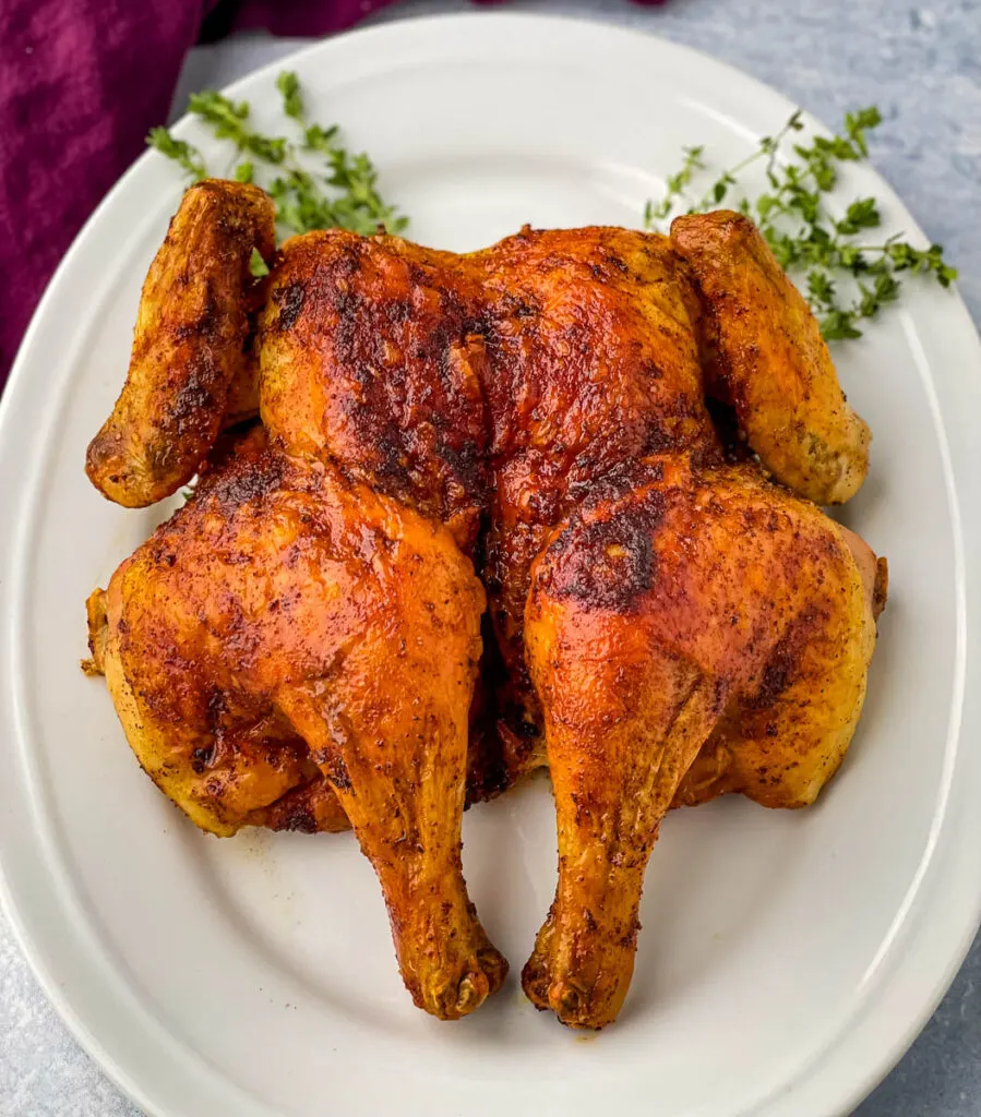 seasoned spatchcock chicken on a white plate