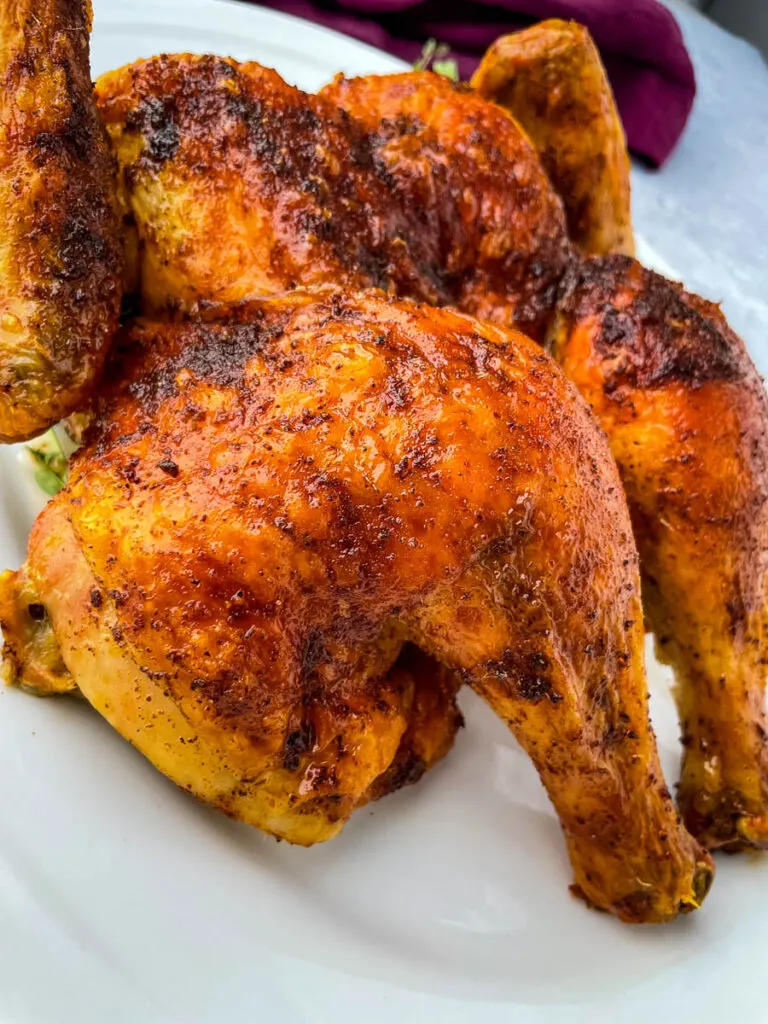 seasoned spatchcock chicken on a white plate