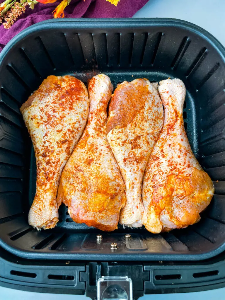 raw seasoned turkey legs in an air fryer