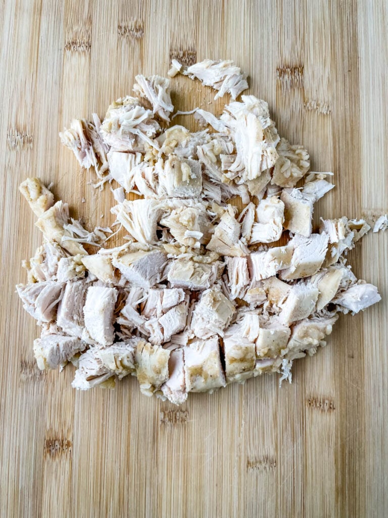 sliced cubed cooked chicken breast on a cutting board