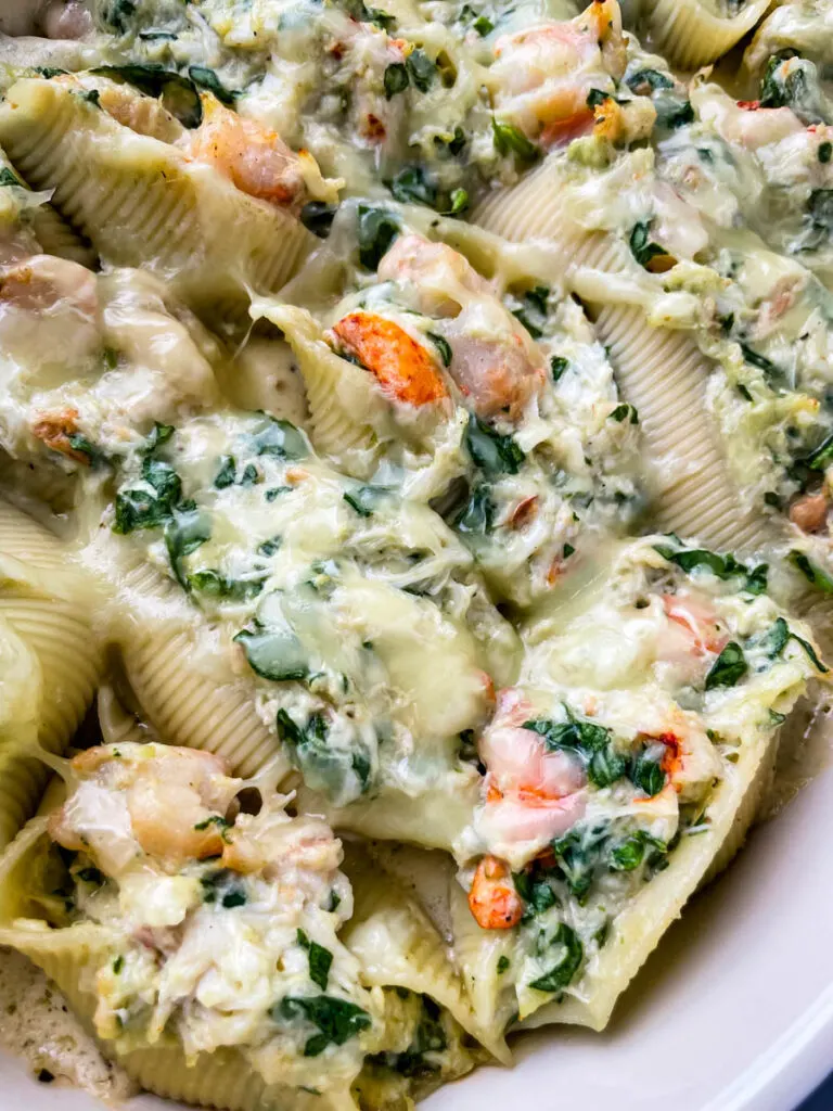 seafood lobster, shrimp, and crab stuffed shells in a baking dish