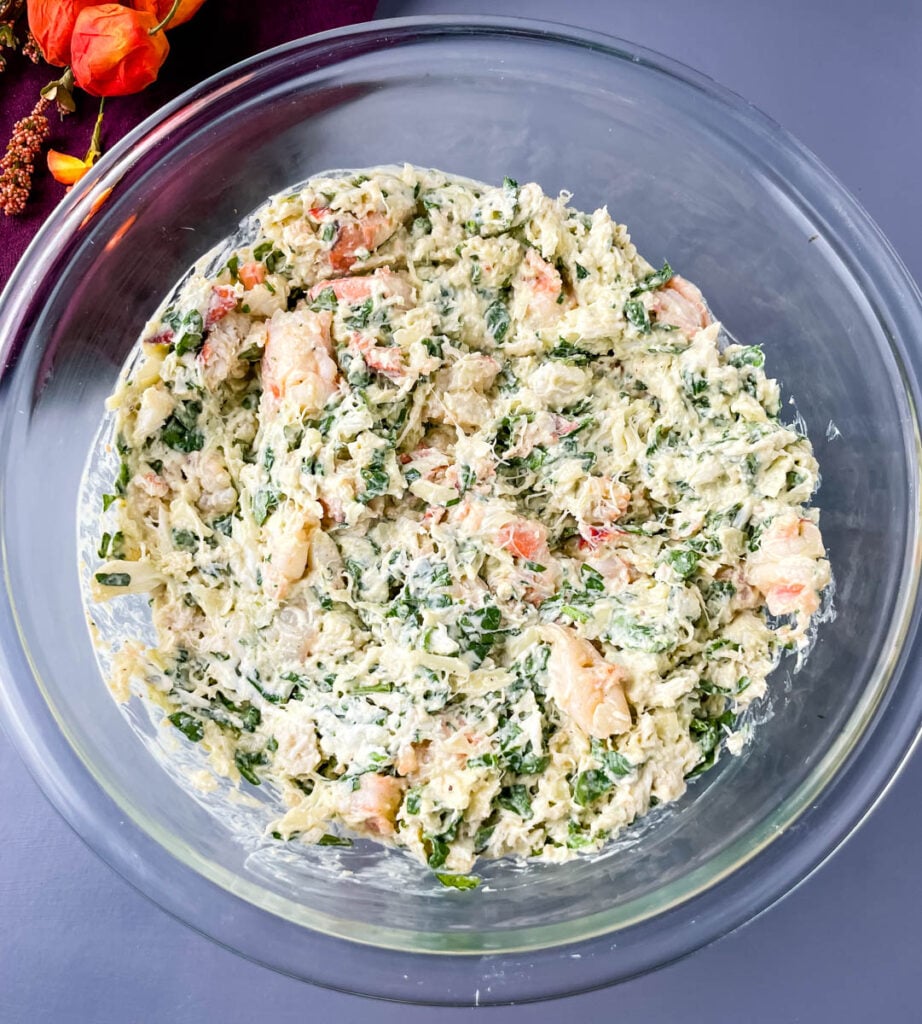 seafood filling with cream cheese and chopped spinach in a glass bowl