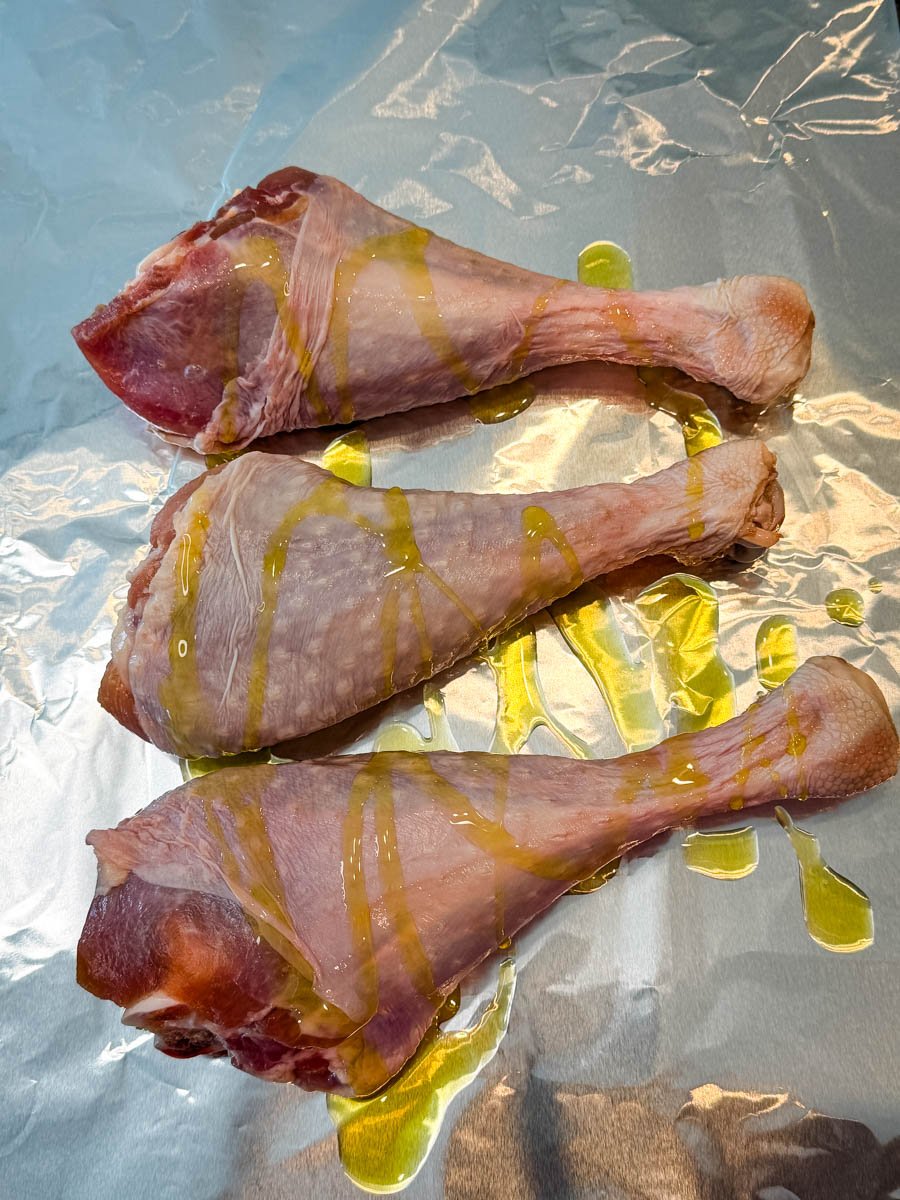 raw turkey legs drizzled in olive oil on foil