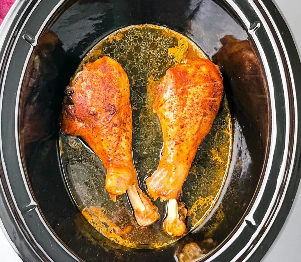 2 cooked turkey legs in a Crockpot slow cooker